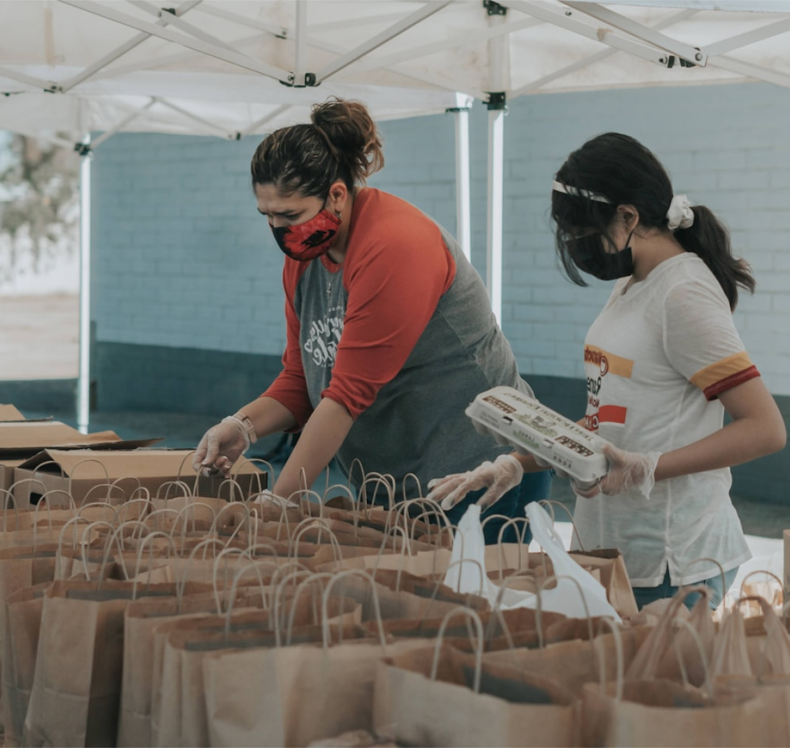 Two volunteers bagging foods